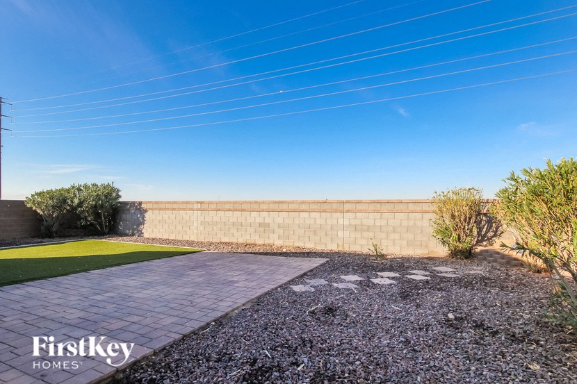 a backyard with a brick wall and a walkway
