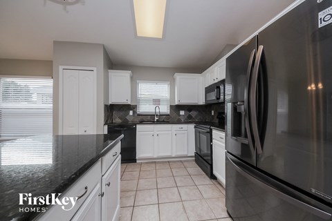 a black and white kitchen with stainless steel appliances and white cabinets