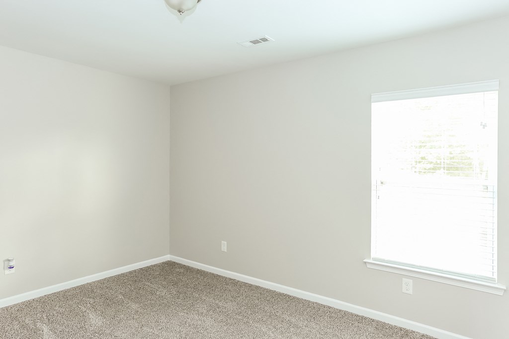 an empty room with carpet and a window