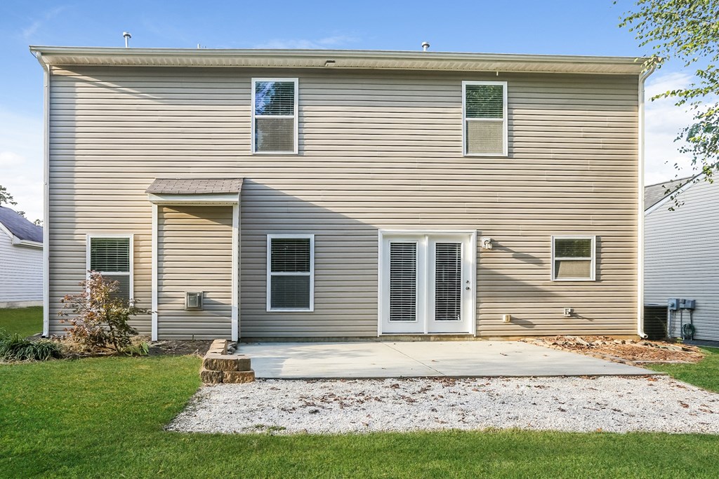 the front of a white house with a concrete driveway