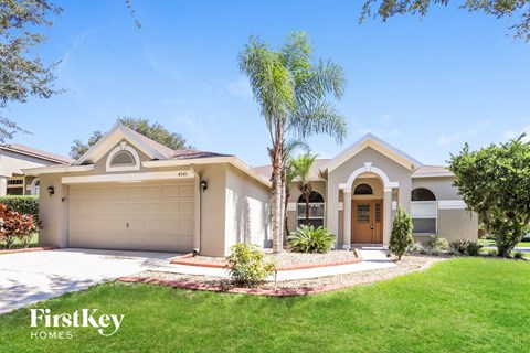 a house with a garage and a palm tree in the yard