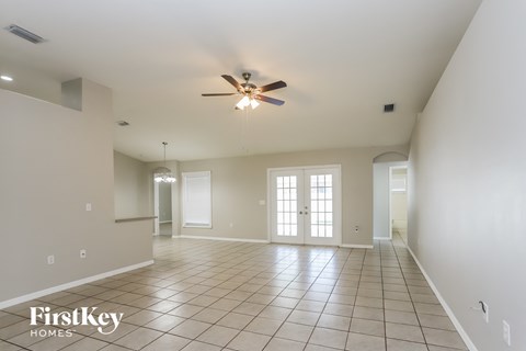 an empty living room with a ceiling fan