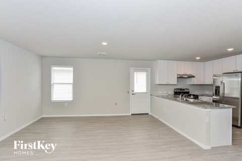 a kitchen with white cabinets and a counter top and a refrigerator