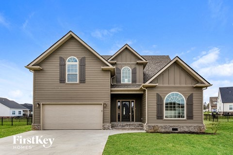 A two-story house with a garage is showcased in the image.