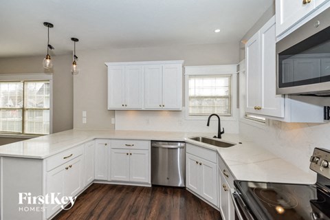 A kitchen with white cabinets and a stainless steel dishwasher.
