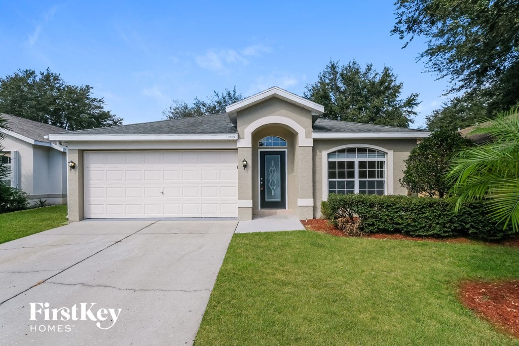 A house with a blue door and a garage is for sale.