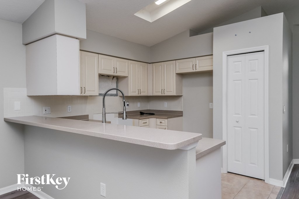 A kitchen with white cabinets and a white counter top.