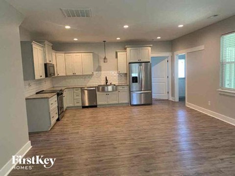 A kitchen with wooden floors and stainless steel appliances.