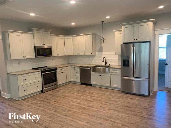 A kitchen with wooden floors and stainless steel appliances.