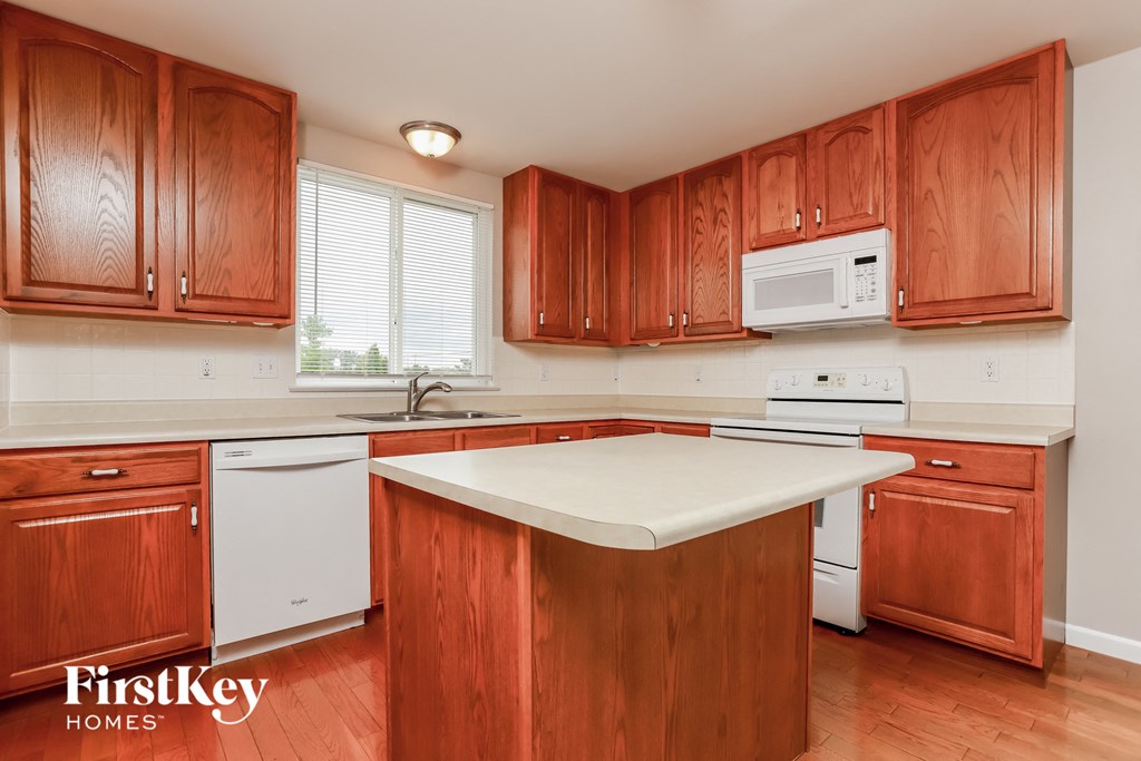 a kitchen with wooden cabinets and a white counter top