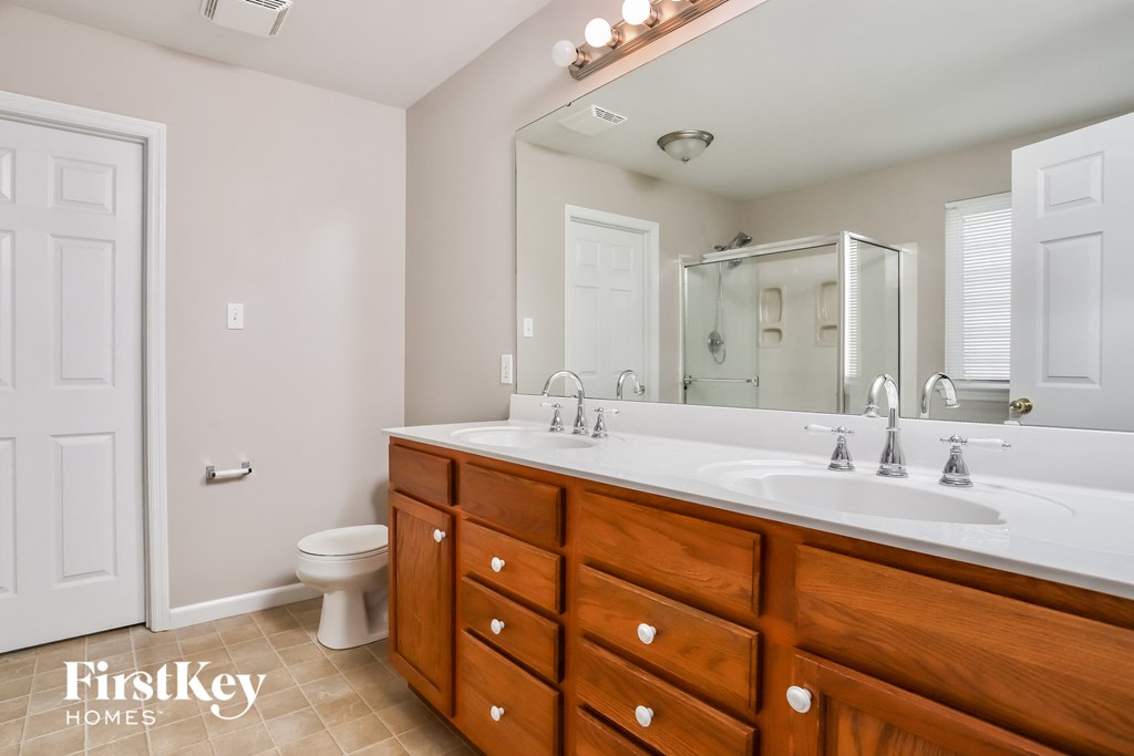 a bathroom with a white sink and a mirror and a toilet