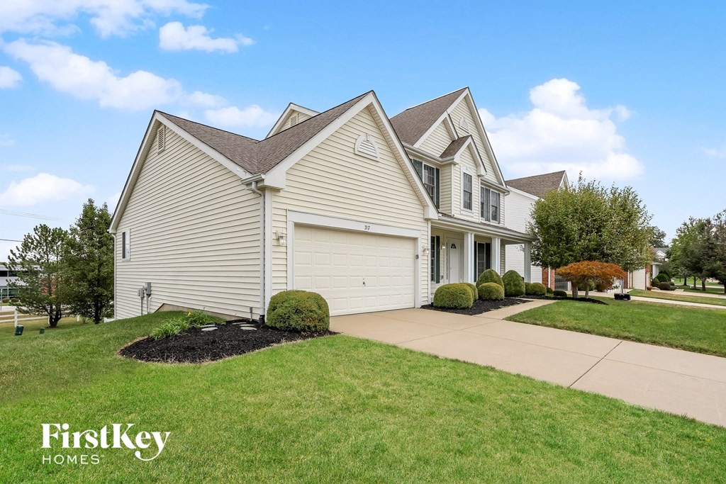 a white house with a lawn and a driveway