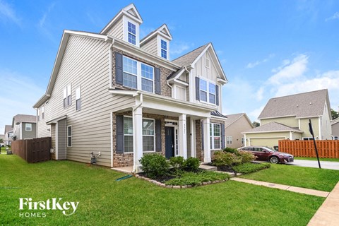 a beige house with a yard in front of it