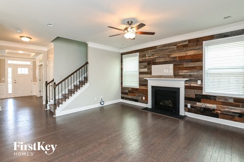 an empty living room with a fireplace and a staircase