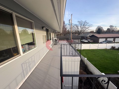 A balcony with a railing overlooking a green field.