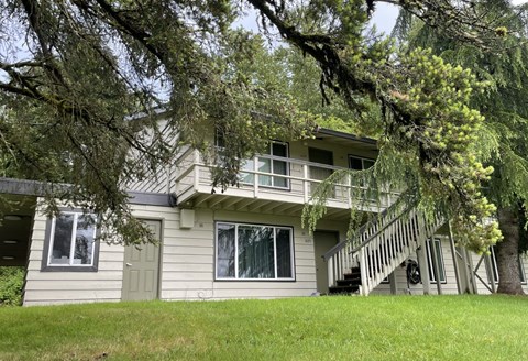A house with a green lawn and trees in the front.
