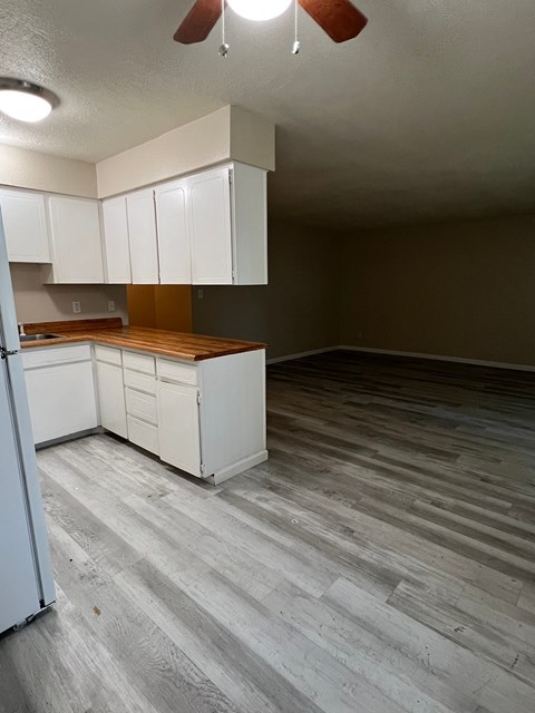 A kitchen with white cabinets and a wooden countertop.