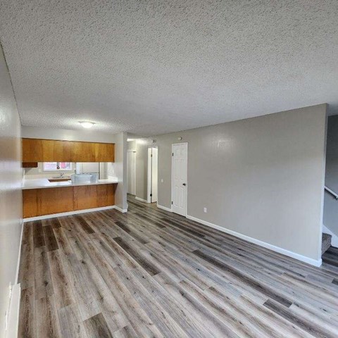 A room with wooden flooring and white walls.