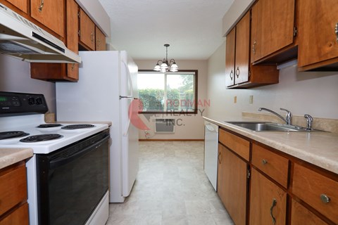 A kitchen with a black stove top oven and a white refrigerator.