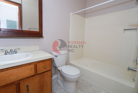 A bathroom with a toilet, sink, and bathtub.