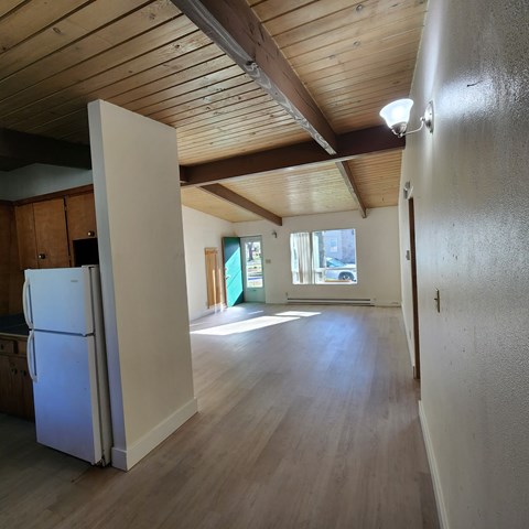 A kitchen with a white refrigerator and wooden cabinets.