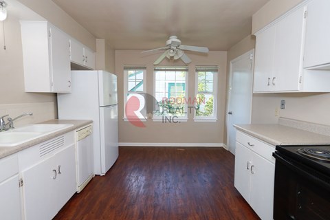 A kitchen with white cabinets and a black stove top oven.