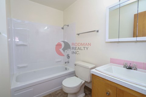 A bathroom with a toilet, sink, and bathtub.