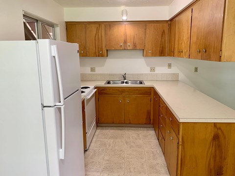 A kitchen with wooden cabinets and a white refrigerator.