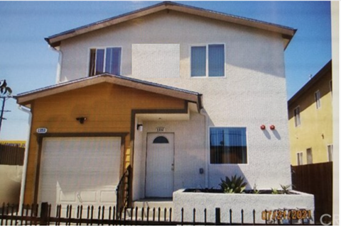 a white house with blue shutters and a white fence
