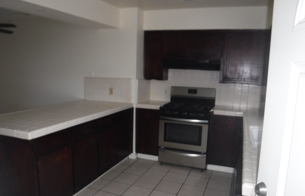 an empty kitchen with a stove and a counter
