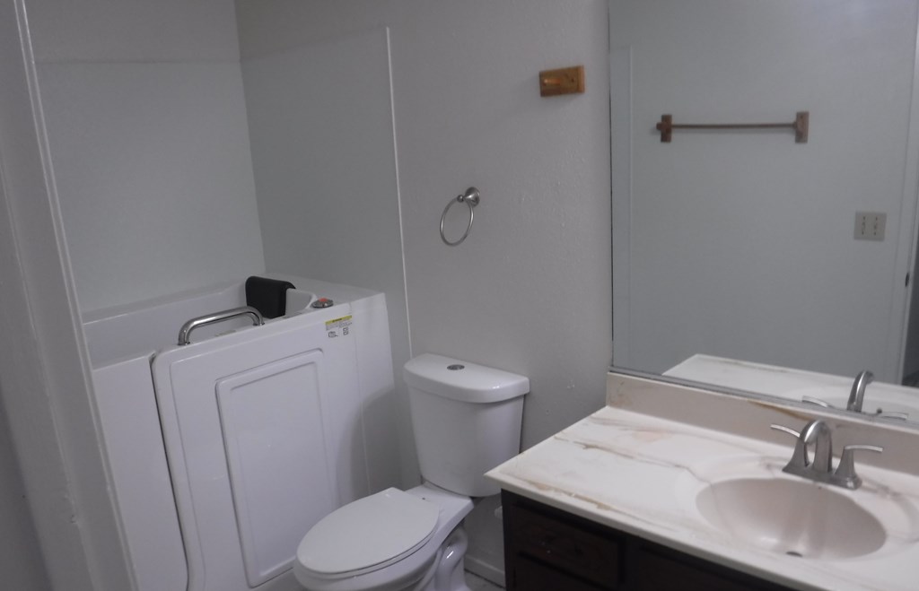 a bathroom with a toilet sink and a mirror