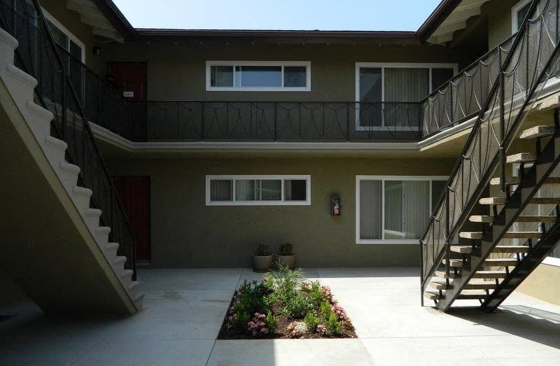 an apartment building with a staircase and a courtyard