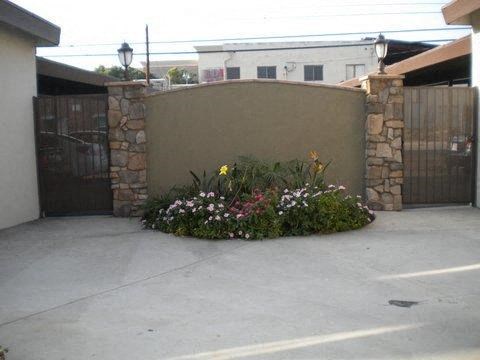 a yard with flowers in front of a fence