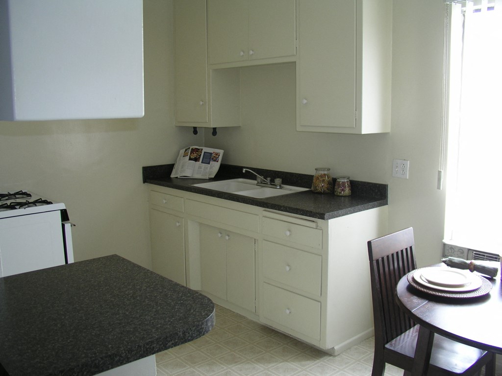 a kitchen with white cabinets and a sink and a table