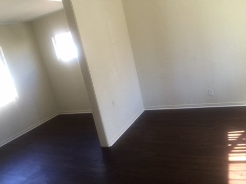 an empty room with a wooden floor and white walls