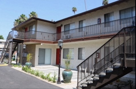 an apartment building with a staircase and a balcony and a roof