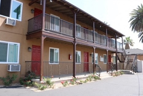 an apartment building with a balcony and a staircase