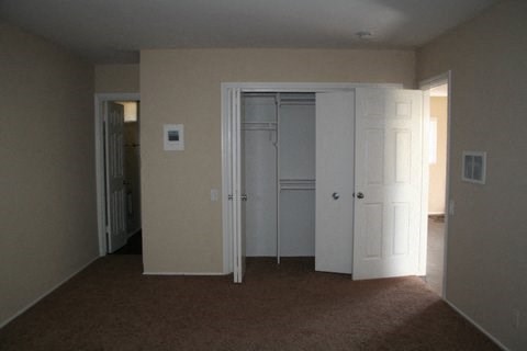 an empty living room with two doors and a closet