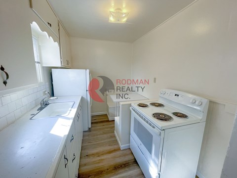 A white stove in a kitchen with a white counter top.