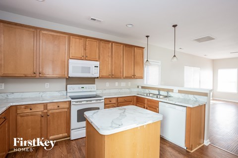 a kitchen with white appliances and wooden cabinets