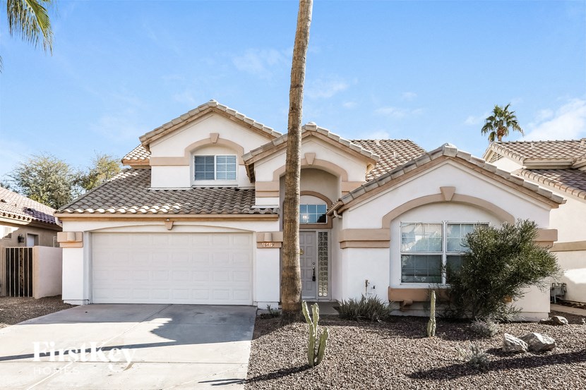 A house with a white garage door and a brown roof.