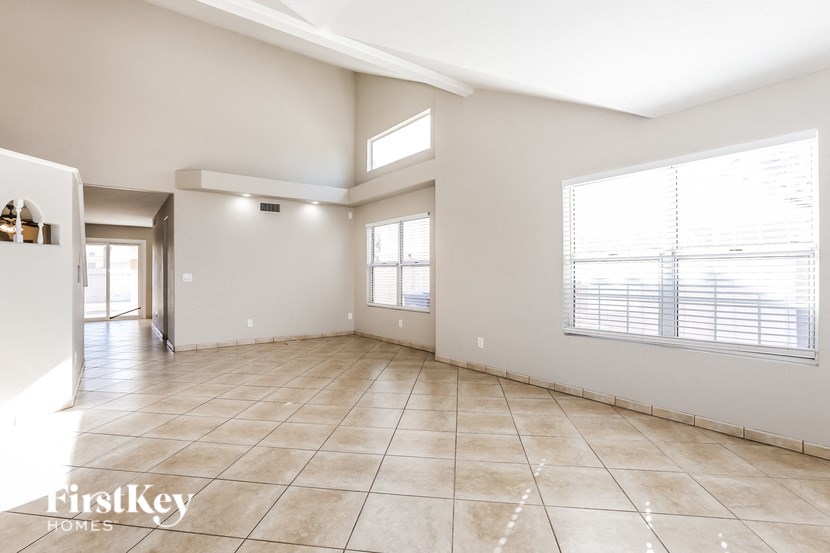 A spacious room with tiled flooring and a large window.
