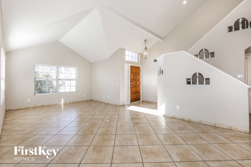 A spacious, empty room with a large window and a wooden door.