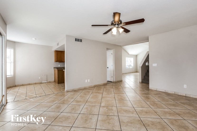 A spacious room with a ceiling fan and tiled flooring.