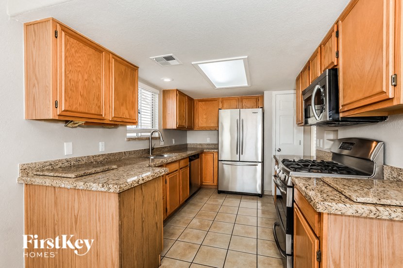 A kitchen with wooden cabinets and a granite countertop.