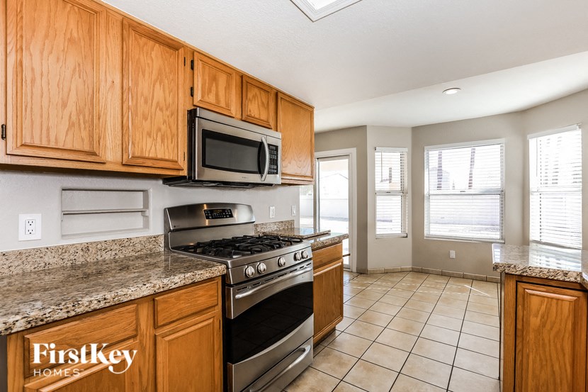 A kitchen with wooden cabinets and a stainless steel stove top oven.