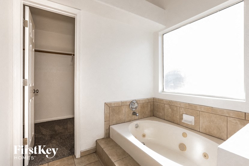A bathroom with a tub and a window.