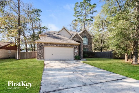 a garage with a white driveway and a brick house