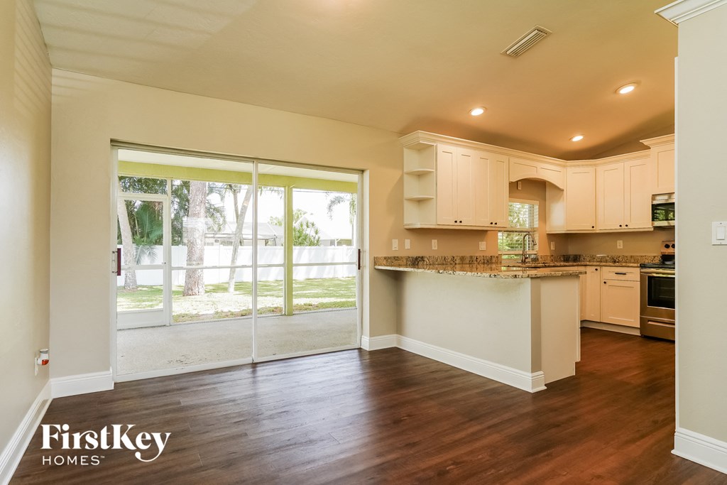 A kitchen with wooden floors and white cabinets.