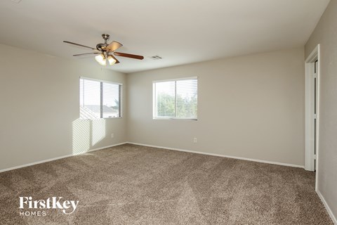 a living room with carpet and a ceiling fan